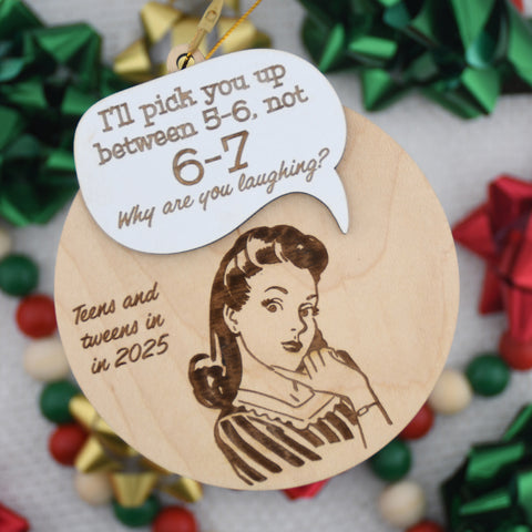 Wooden ornament with a vintage-style illustration and humorous text, surrounded by festive decorations.