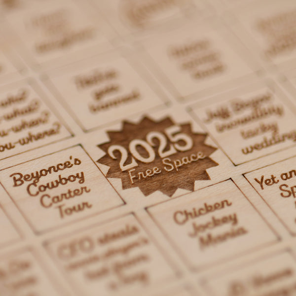 Wooden calendar with laser-cut dates and event text, featuring the year 2025.