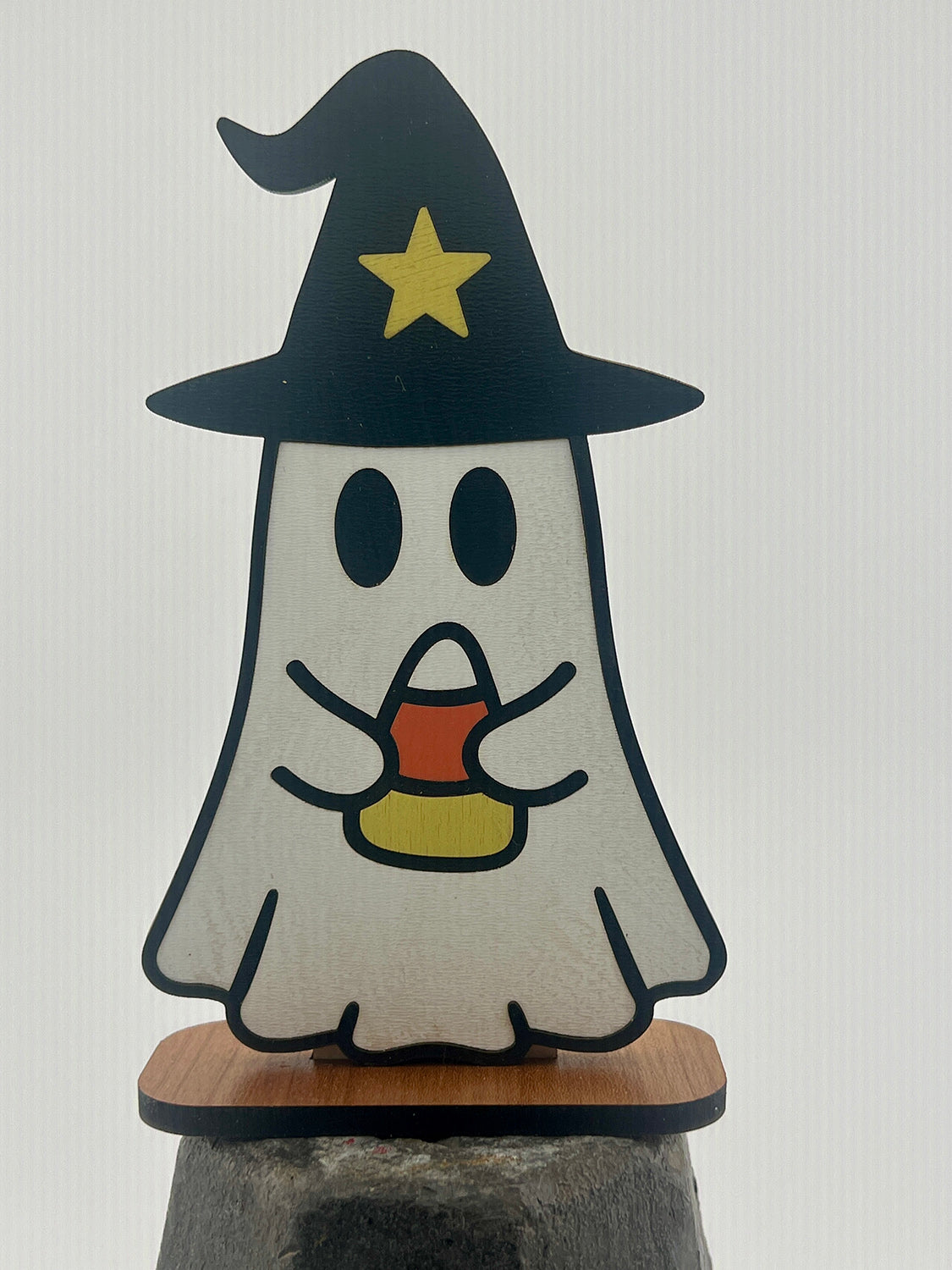 Halloween-themed ghost figurine with a witch hat and candy corn on a white background