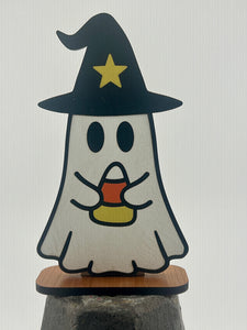 Halloween-themed ghost figurine with a witch hat and candy corn on a white background