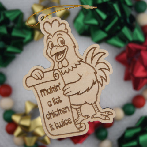 Wooden ornament with a chicken holding a sign and surrounded by festive bows.