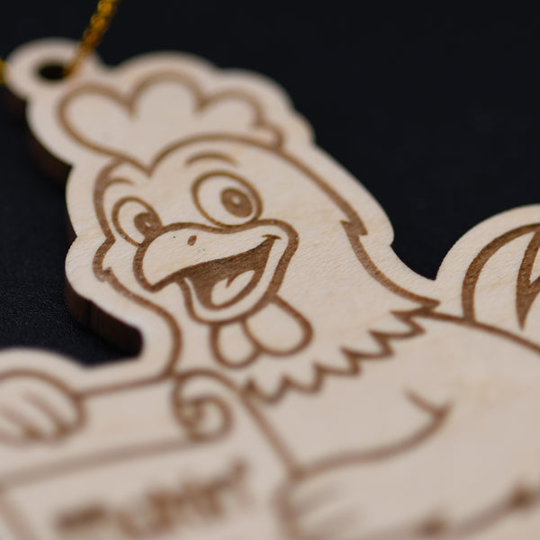 Wooden ornament shaped like a cartoon rooster on a dark background