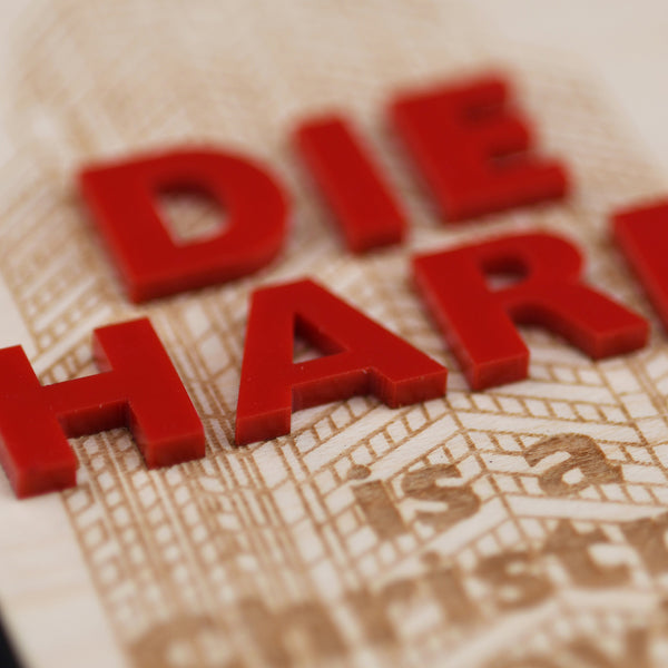 Red letters spelling 'DIE HARI' on a textured surface