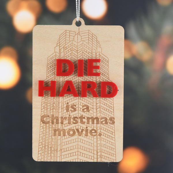 Decorative tag with 'DIE HARD is a Christmas movie' text on a blurred lights background