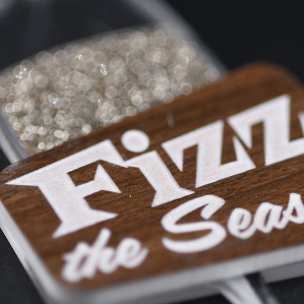 Close up of ornament with 'Fizz the Season' text