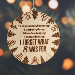Wooden ornament with Christmas-themed text and patterns on a tree background