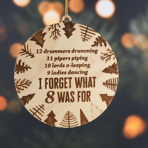 Wooden ornament with Christmas-themed text and patterns on a tree background