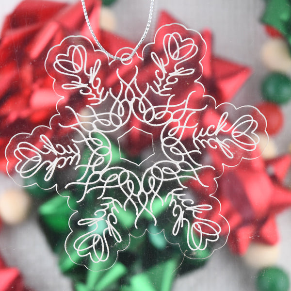 Acrylic ornament with hidden "fuck" words, on a blurred bow background