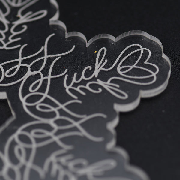Close up of the word "fuck" as engraved in a snowflake ornament