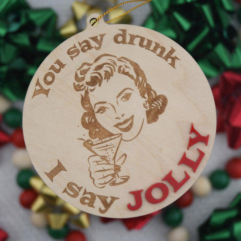 Wooden ornament with a woman holding a martini and text 'You say drunk, I say Jolly' on a blurred bow background
