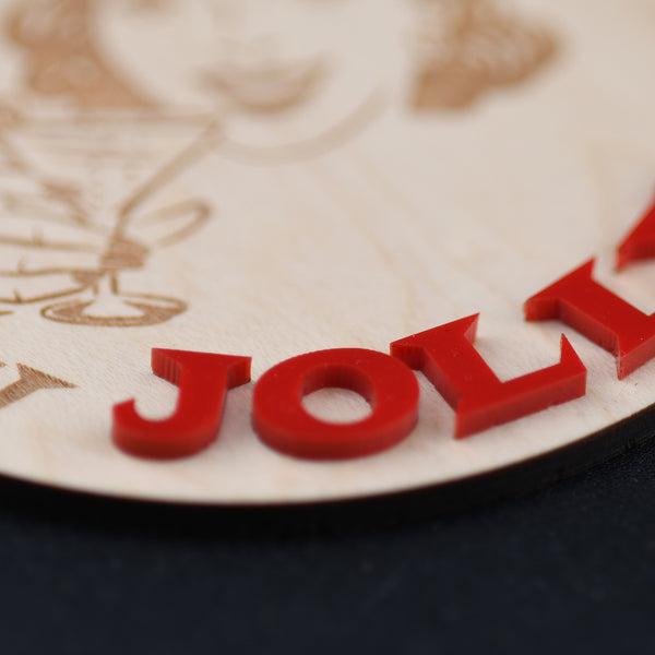 Close-up of a red 'Jolly' text on a wooden surface with intricate carvings.