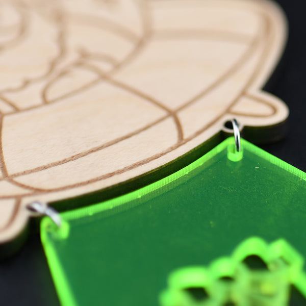 Decorative ornament with Santa Claus in an UFO and a green base with a gift icon, close up